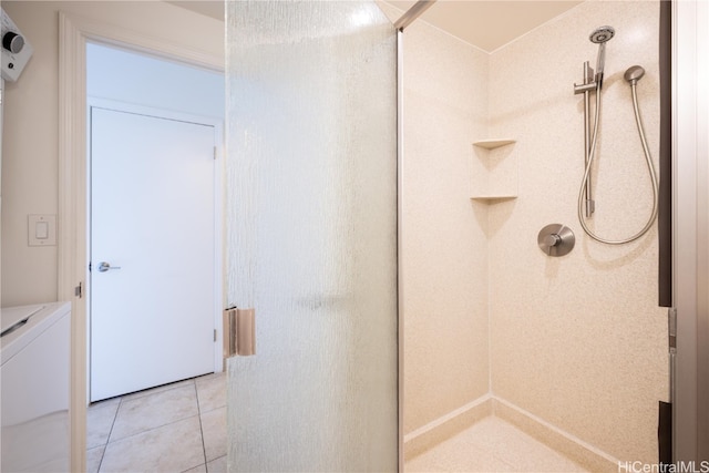 bathroom with independent washer and dryer, walk in shower, and tile patterned flooring