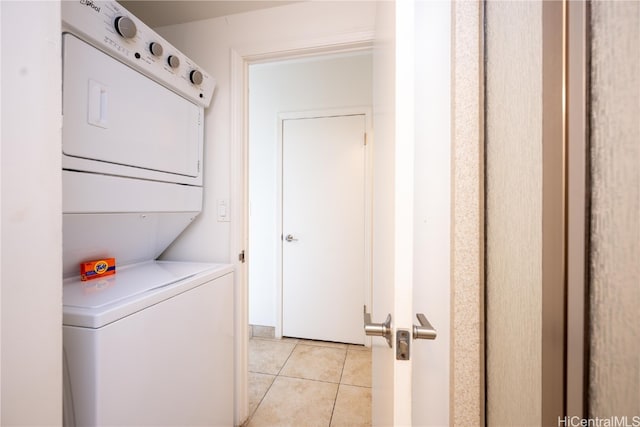 laundry area featuring light tile patterned floors and stacked washer and dryer