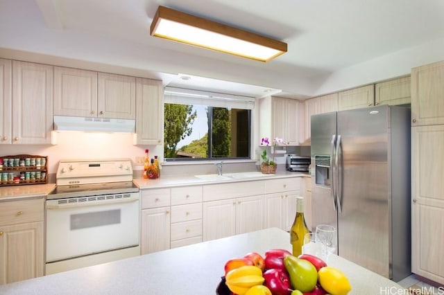 kitchen with white range with electric stovetop, sink, and stainless steel fridge