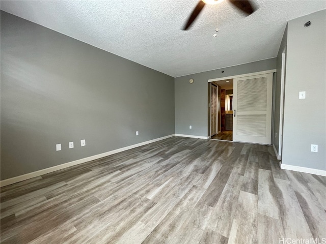 unfurnished room featuring light hardwood / wood-style flooring, a textured ceiling, and ceiling fan