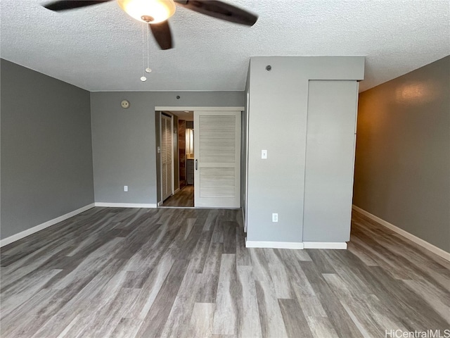 unfurnished bedroom featuring hardwood / wood-style floors, a textured ceiling, and ceiling fan