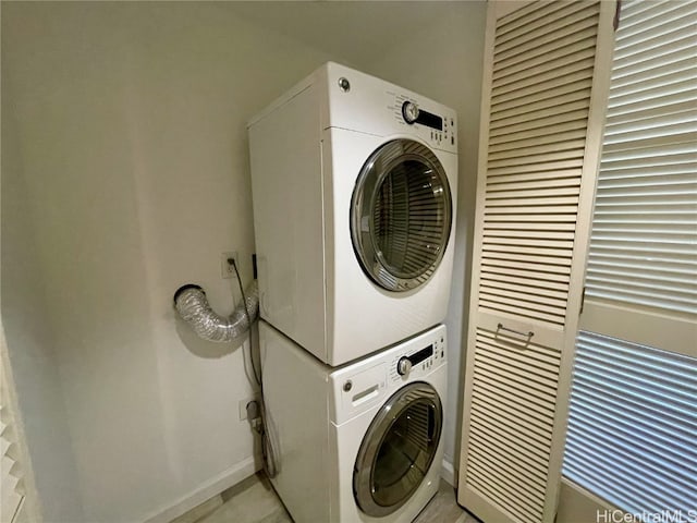 washroom featuring stacked washer and clothes dryer