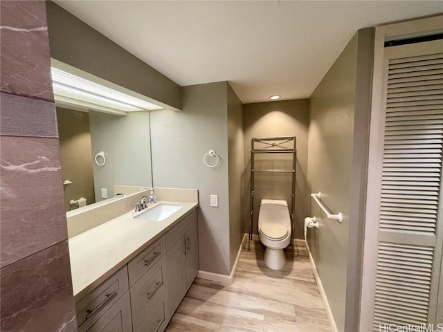 bathroom featuring vanity, toilet, and hardwood / wood-style flooring