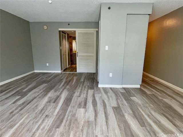 unfurnished bedroom featuring a textured ceiling and light hardwood / wood-style floors