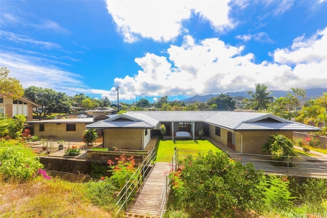 view of front of property featuring a mountain view and a patio