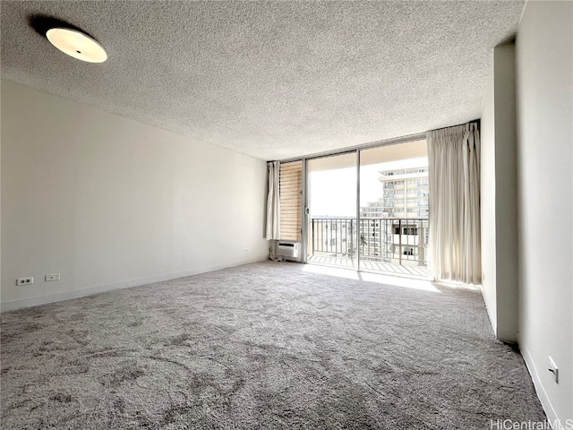 unfurnished living room with carpet, a textured ceiling, and floor to ceiling windows