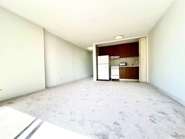 unfurnished living room featuring light colored carpet and baseboards
