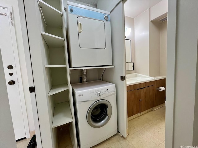 clothes washing area with stacked washer and dryer, laundry area, and light floors
