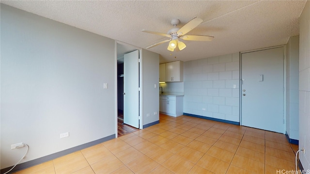 tiled spare room featuring ceiling fan and a textured ceiling