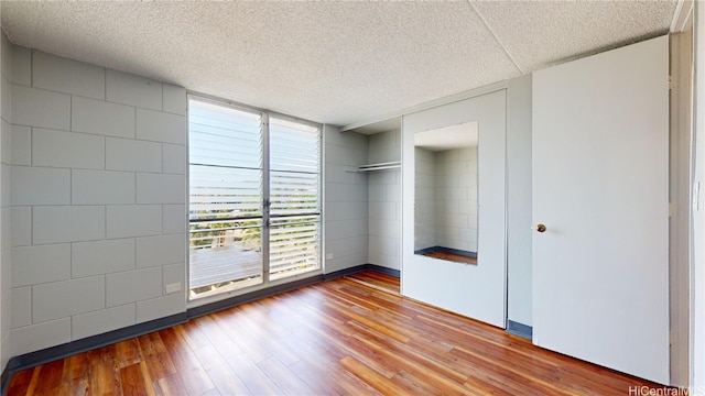 empty room featuring a textured ceiling and wood-type flooring