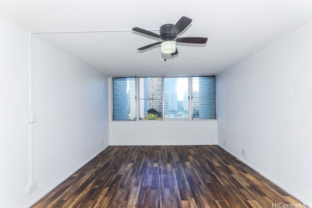 spare room with dark wood-type flooring, ceiling fan, and a textured ceiling