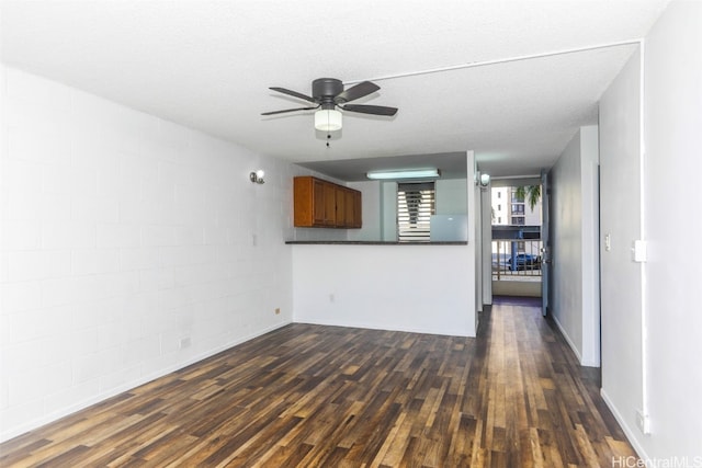 unfurnished living room with dark hardwood / wood-style floors, a textured ceiling, and ceiling fan