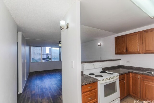 kitchen featuring white electric range, ceiling fan, a textured ceiling, and dark hardwood / wood-style flooring