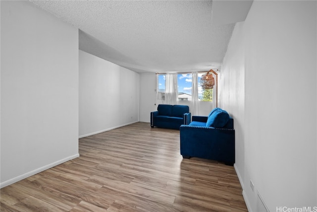 living room featuring a textured ceiling and light wood-type flooring