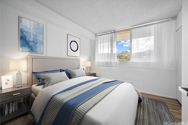 bedroom with hardwood / wood-style flooring and a textured ceiling