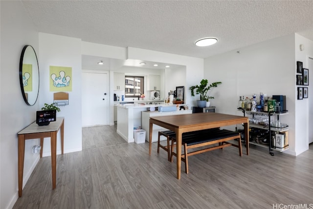 dining area featuring a textured ceiling and light wood-type flooring