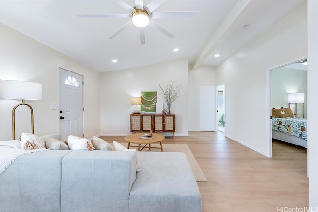 living room with ceiling fan, lofted ceiling, and light hardwood / wood-style flooring