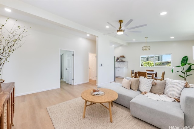 living room with light hardwood / wood-style flooring, lofted ceiling, and ceiling fan