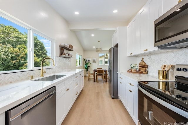 kitchen with sink, appliances with stainless steel finishes, decorative backsplash, and white cabinetry