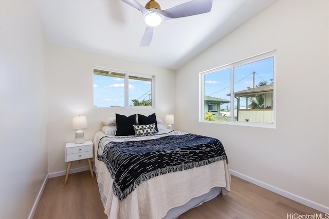 bedroom with multiple windows, hardwood / wood-style floors, and ceiling fan