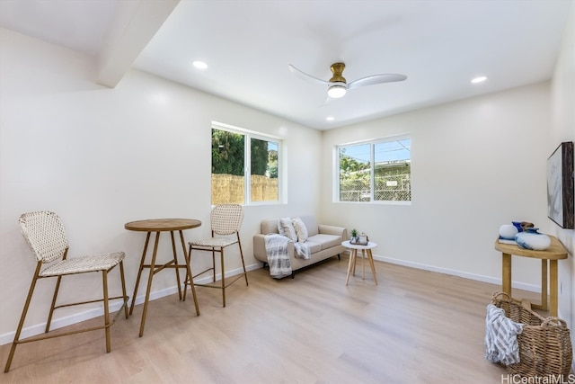 living area featuring light hardwood / wood-style floors and ceiling fan