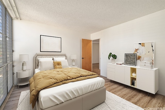 bedroom with wood-type flooring and a textured ceiling