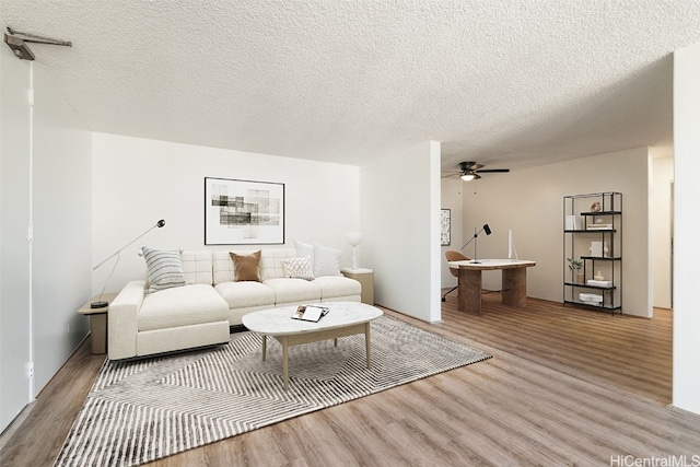 living room featuring a textured ceiling, hardwood / wood-style flooring, and ceiling fan