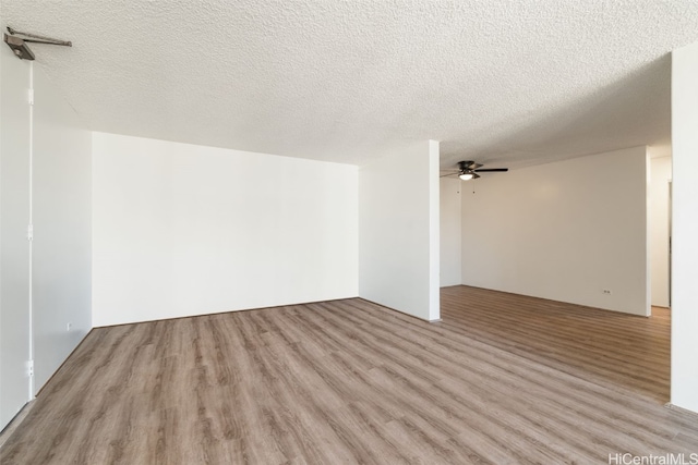 spare room featuring light hardwood / wood-style flooring, a textured ceiling, and ceiling fan