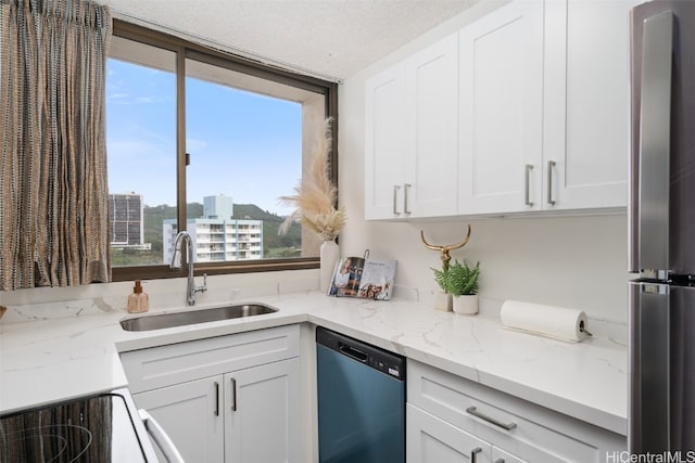 kitchen featuring a wealth of natural light, sink, appliances with stainless steel finishes, and a textured ceiling