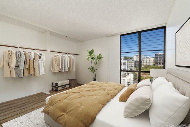 bedroom with hardwood / wood-style floors and a textured ceiling