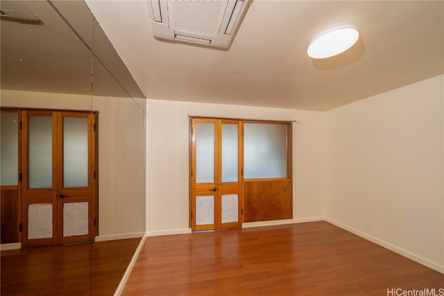 spare room featuring french doors and dark hardwood / wood-style flooring