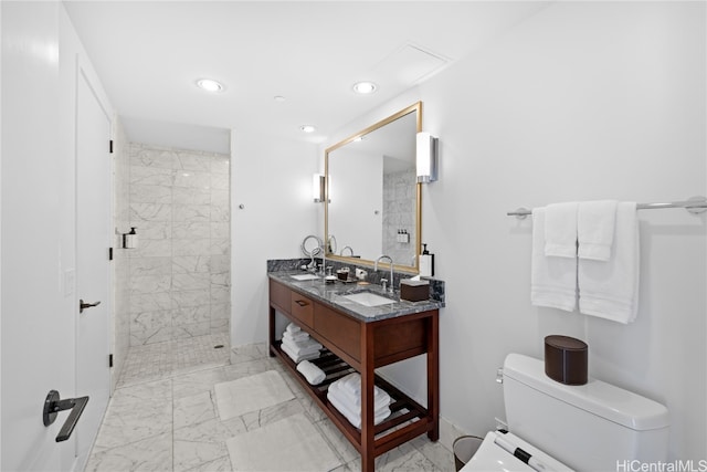 bathroom with a shower with door, vanity, and toilet