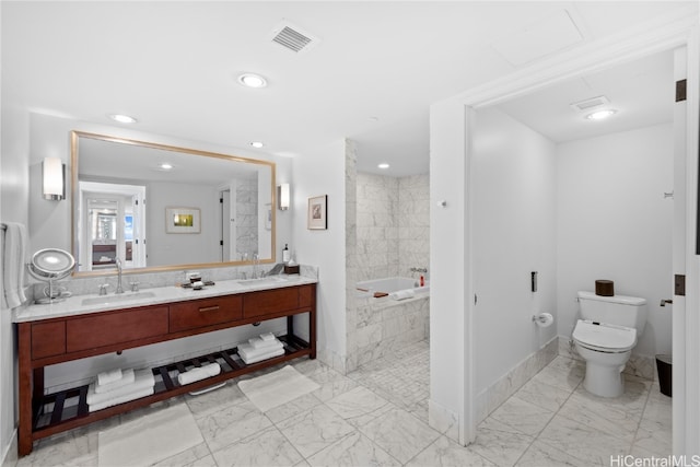 bathroom with a washtub, vanity, and toilet