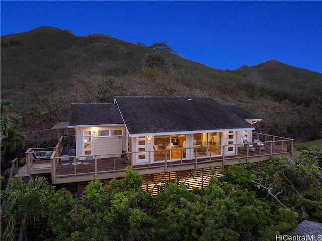 rear view of house with a deck with mountain view