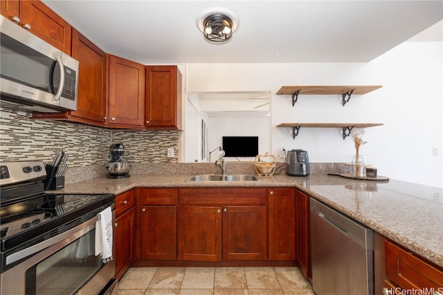 kitchen featuring appliances with stainless steel finishes, tasteful backsplash, sink, and light stone counters