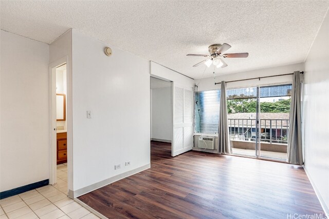 spare room with baseboards, wood finished floors, a textured ceiling, and ceiling fan