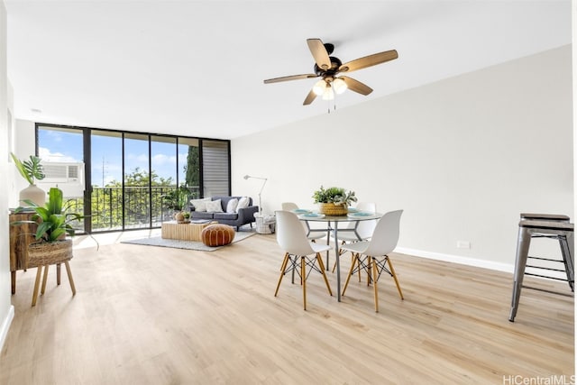 dining space with ceiling fan, a wall of windows, and light hardwood / wood-style flooring