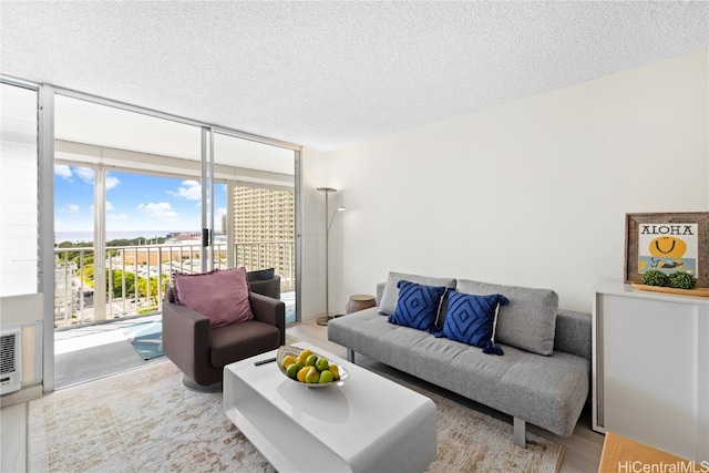 living room featuring floor to ceiling windows, a textured ceiling, plenty of natural light, and hardwood / wood-style floors