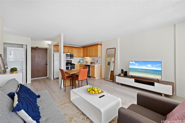 living room with a textured ceiling and light wood-type flooring