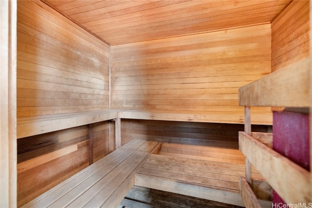 view of sauna / steam room with wooden ceiling and wood walls