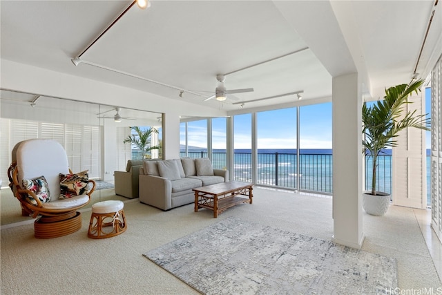 sunroom with a water view and ceiling fan