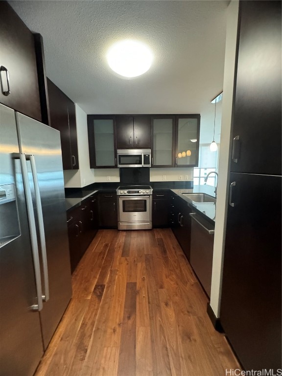 kitchen featuring a textured ceiling, appliances with stainless steel finishes, sink, and dark hardwood / wood-style floors