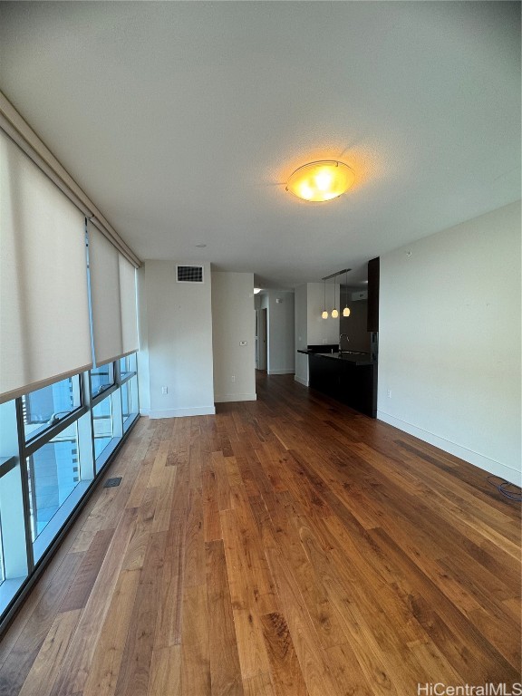 unfurnished living room featuring sink and hardwood / wood-style flooring