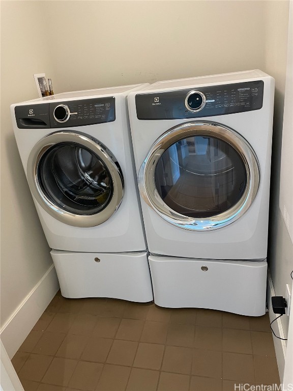 washroom featuring washing machine and clothes dryer and dark tile patterned floors