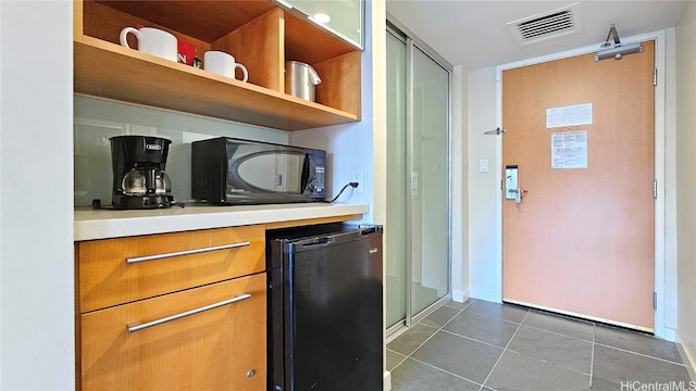 kitchen with black appliances and dark tile patterned floors