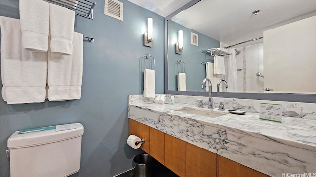 bathroom with vanity, curtained shower, and toilet