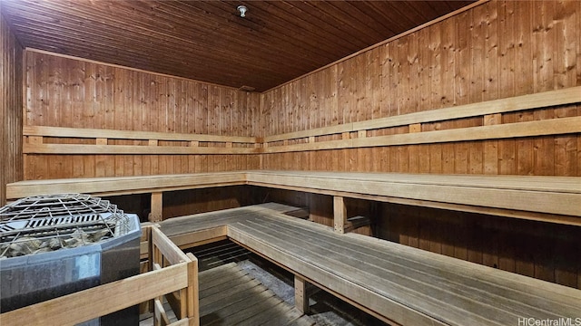 view of sauna featuring wood ceiling and wood walls