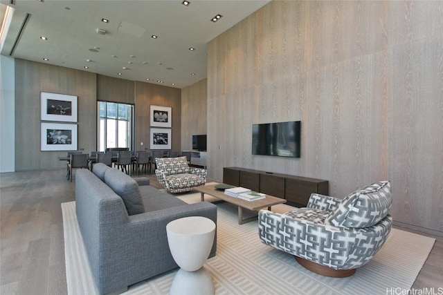 living room with hardwood / wood-style floors and a towering ceiling