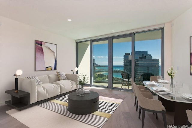 living room featuring floor to ceiling windows, a water view, and hardwood / wood-style flooring