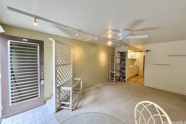 carpeted spare room with track lighting and ceiling fan